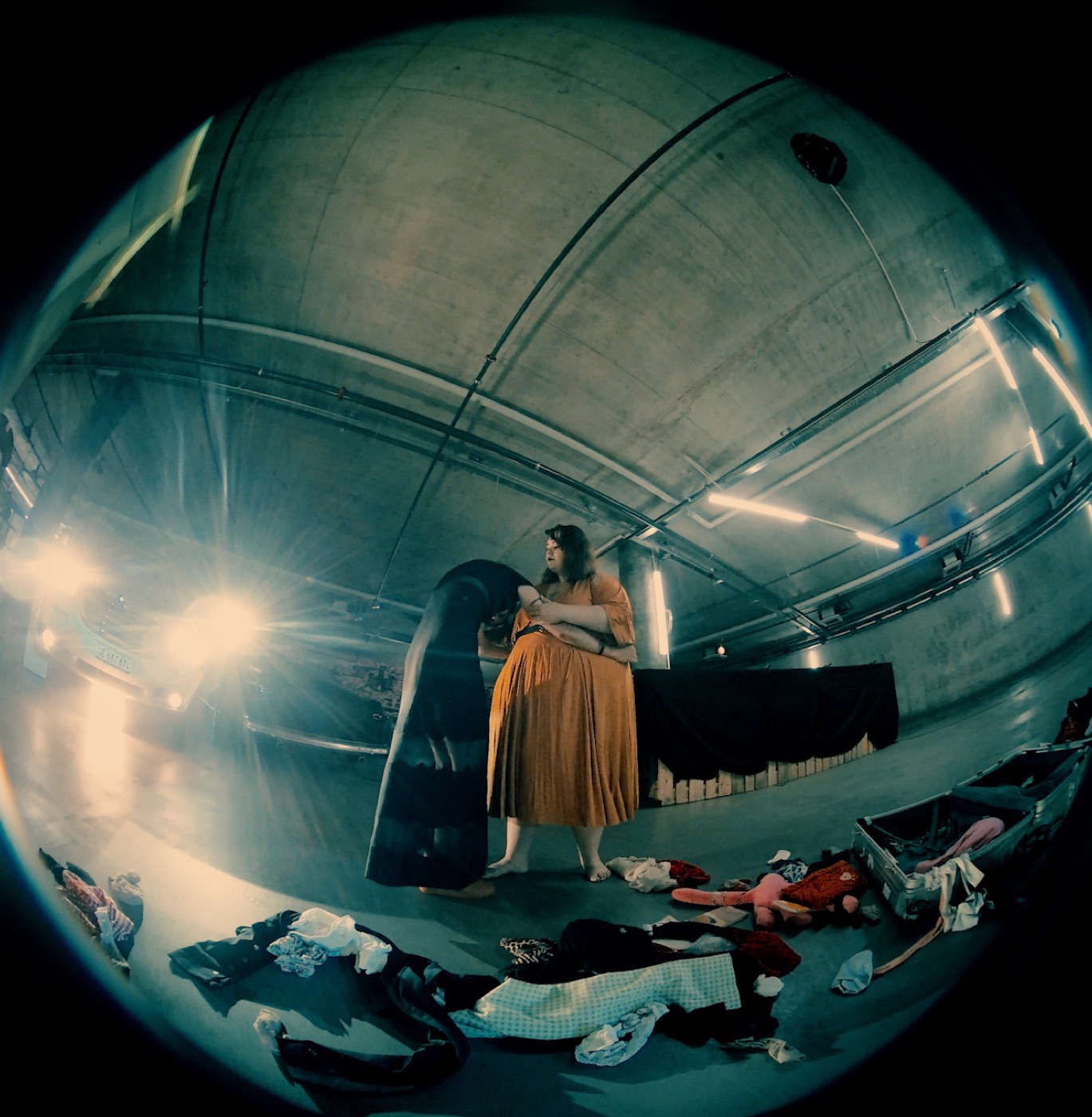 TERRAIN still: performer dressing in an underground garage