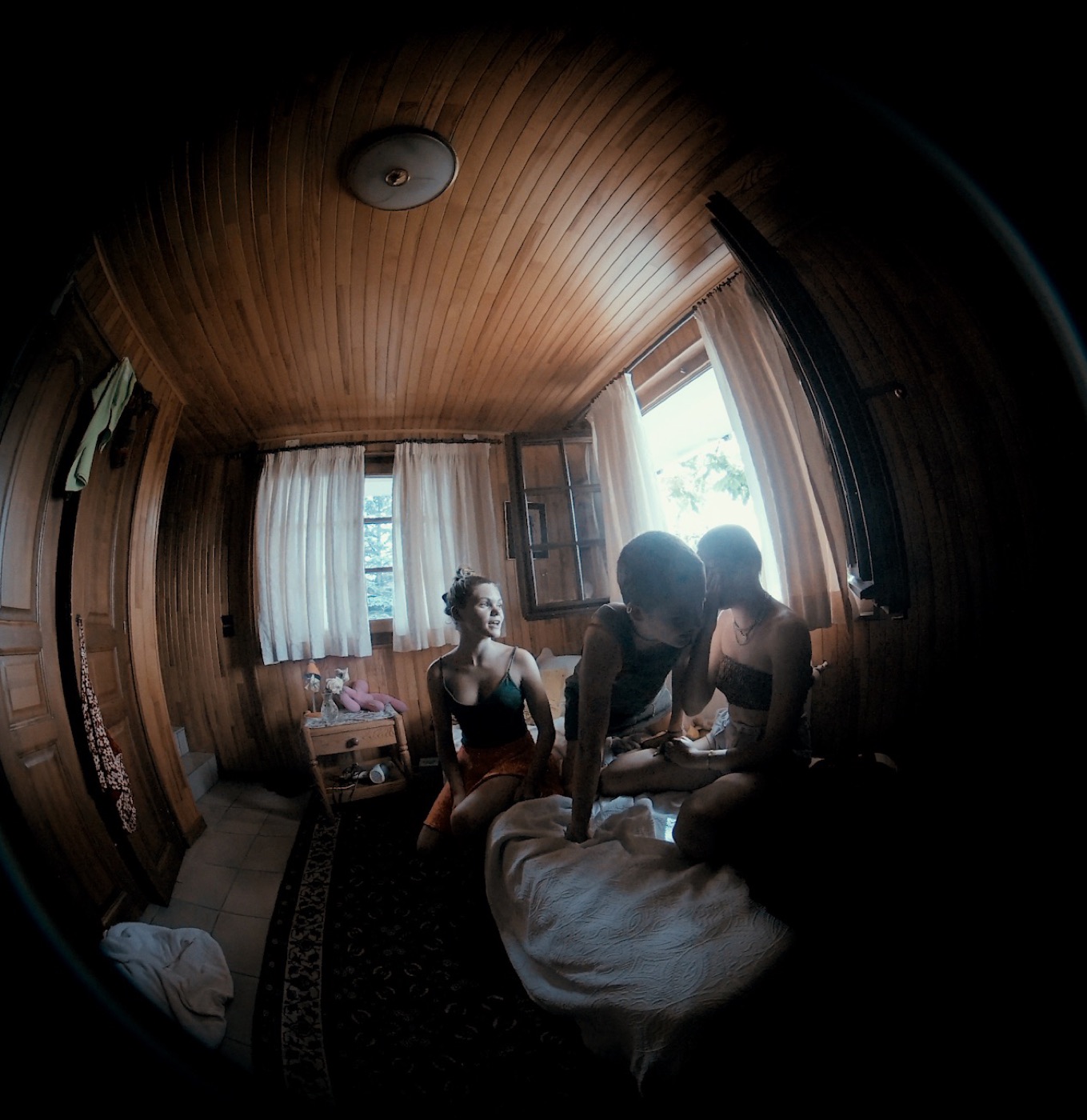 TERRAIN still: three performers in a wooden chalet bedroom